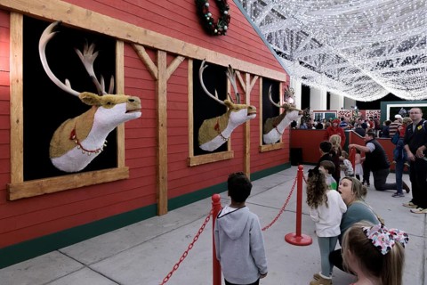 Children listen to animatronic reindeer inside the Barksdale Pavilion during the Harbor Lights