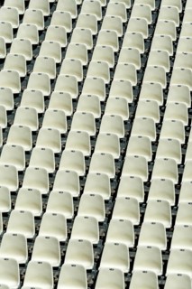 Empty stadium seats arranged in neat rows highlight the readiness for an upcoming sports event or