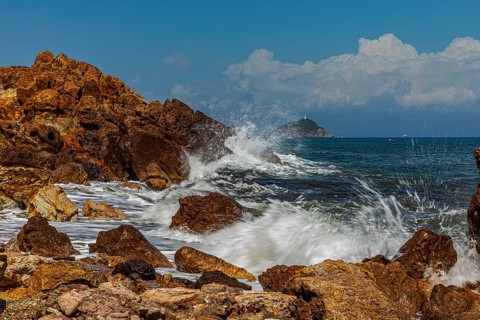 Rugged rocks and foaming spray on Topinetti beach, near Rio Marina, Elba Island, Tuscan Archipelago