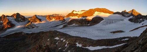 Picturesque high mountain landscape at sunrise with alpenglow, blue glacial lakes, glaciers and