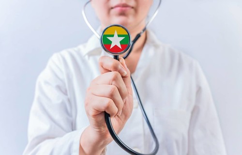 Female doctor holding stethoscope with Myanmar flag. National health system of Myanmar