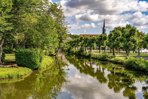 The river Loir and Notre-Dame church in Alluyes, Centre-Val de Loire, France