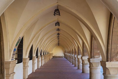 Long covered portico with arches and patterned floor, harbour area, Rhodes Town, Rhodes,