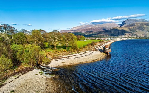 View of Corpach Wreck or Old Boat of Caol and Nevis Range Mountains from a drone, Caol Beach,