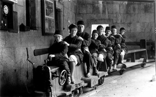 Family on a small railway, 1920s, A family sits together on a small mine train in tunnels,