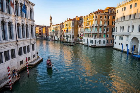 View of the Grand Canal with gondoliers at sunset, picturesque evening mood with palazzos on the