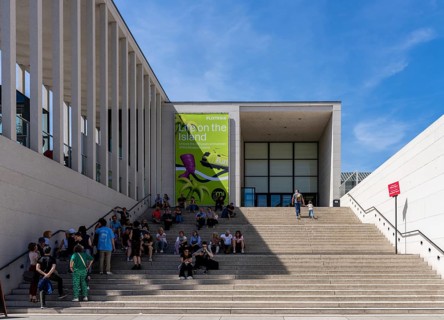 Tourists sitting on the stairs to the James Simon Gallery, Berlin, Germany