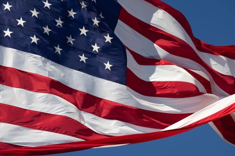 American flag waving in the wind against deep blue sky