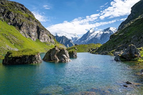 Mountain lake with view of glaciated mountain peaks, Lac du Louvie with summit Grand Combine,