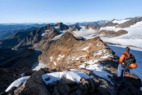 Mountaineer on a rocky ridge on the Wilder Freiger summit, behind him Signal summit and Becher