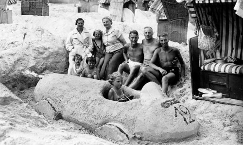 Sand car beach chair family, 1930s, family on the beach posing around a large sand car, relaxed and