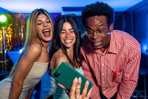 Cheerful multi ethnic friends gathering together, capturing a fun selfie at a vibrant party,