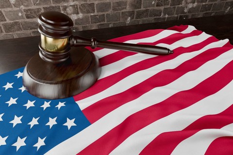 American flag and wooden gavel resting on desk