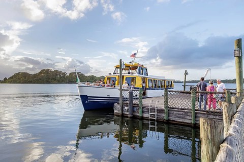 Water taxi boat with passengers approaching the dock of Fort Wilderness campground at Walt Disney