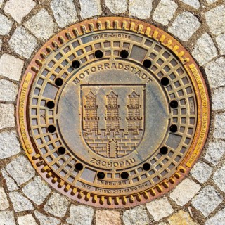 Manhole cover with the coat of arms of the motorbike town of Zschopau, Erzgebirge, Saxony, Germany