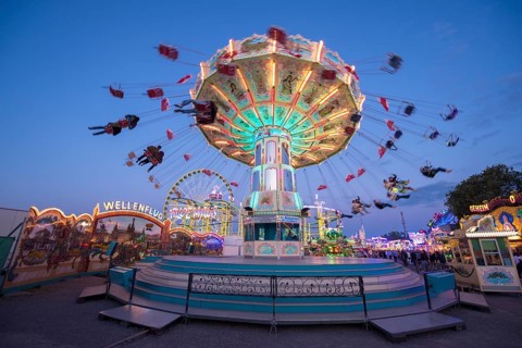 Lively carousel illuminated at a night fair, chain carousel, spring festival, Cannstatter