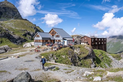 Mountaineer in front of mountain hut Cabane de Prafleuri in mountain landscape, Valais, Western