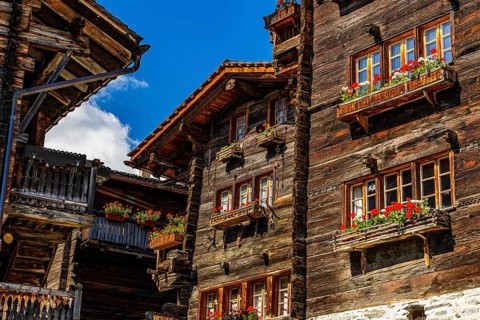 Old wooden houses in log construction, decorated with flowers, historic village centre, Grimentz,