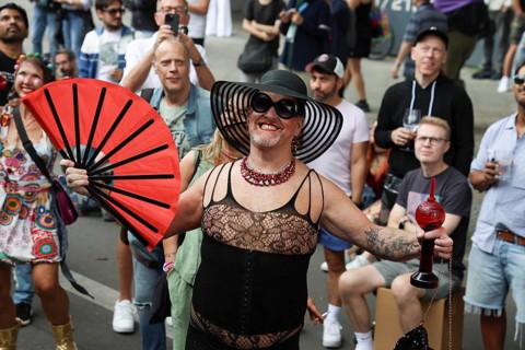 Man in net outfit with fan at the 47th Christopher Street Day under the motto Never again silent in