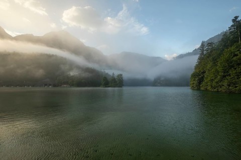 Mystical morning at Königssee in Schönau with boathouses and Christlieger. Sunrise and beautiful