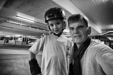 Boy, blonde, 6 years old, crash helmet, protective clothing, posing with older man for selfie,