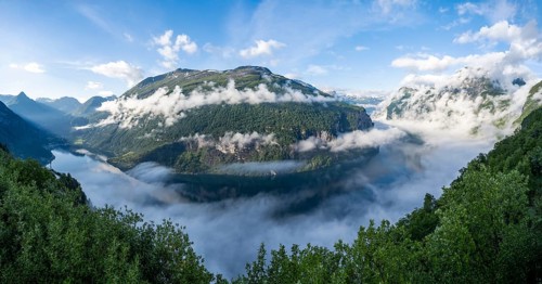 Panorama, view over the Geirangerfjord, atmospheric clouds over the fjord in the morning light,