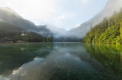 Mystical morning at Königssee in Schönau with boathouses and Christlieger. Sunrise and beautiful