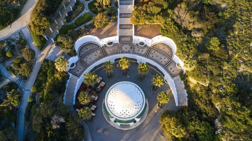 Drone shot, morning light, Symmetrical arrangement of buildings and gardens around a central dome,