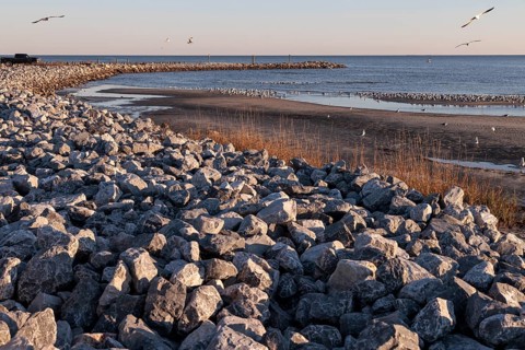 Rock jetty for erosion control contains the tidal waters of the Mississippi Sound along the
