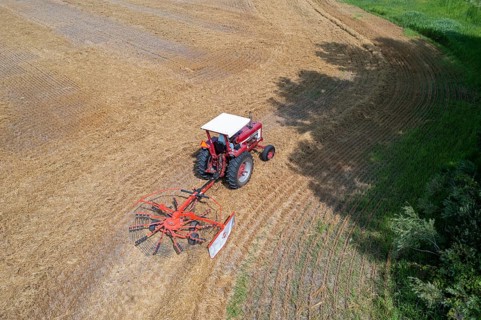 Wayland, Michigan - A farmer uses a rotary tedder to aerate his crop. A tedder spreads out hay or