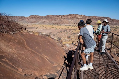 Tourists with guide at the rock engravings of Twyfelfontein, Twyfelfontein, Kunene, Namibia