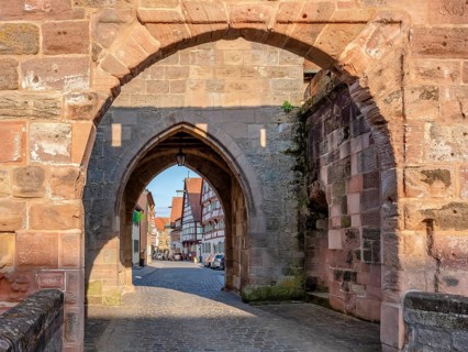 Alley with cobblestones leads through the town gate Oberes Tor, view through the gate to the