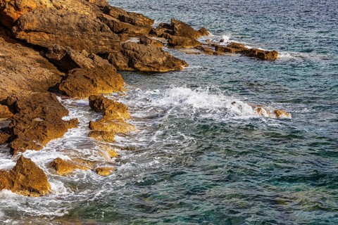 Rugged rocky coastline and foaming spray, on Stecci beach, near Capoliveri, Elba Island, Tuscan
