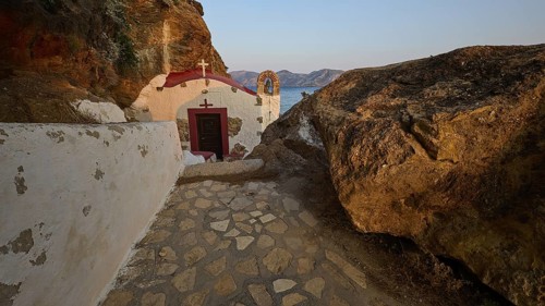 Legend, crab, shell fisherman, stone path to the chapel on the coast, surrounded by rocks, with