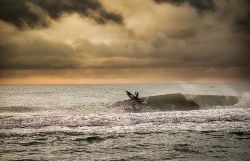Fisherman in a traditional dugout canoe in the surf of the Indian Ocean on the east coast of