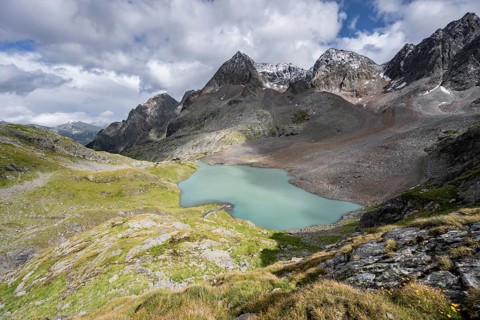 View of the turquoise-blue mountain lake Großer Gradensee, with the peaks of Petzeck and