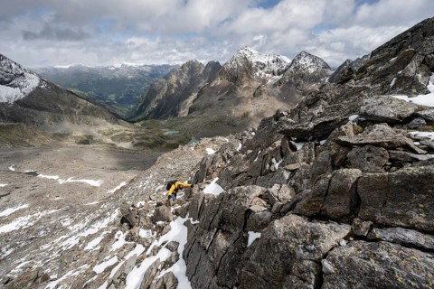 Mountaineer in rocky mountain landscape, descent from the summit of Keeskopf, behind summit of
