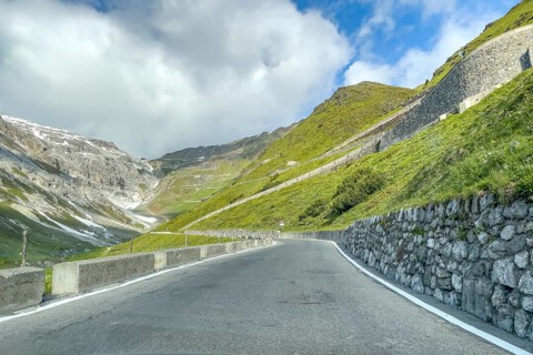 View of east ramp ascent to descent from Alpine pass Stelvio Stilfserjoch mountain road above tree