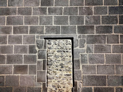 This structure features a stone wall of rough masonry with a distinct doorway outlined in