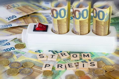 Symbolic image of electricity costs: multiple socket with euro banknotes and euro coins, with the