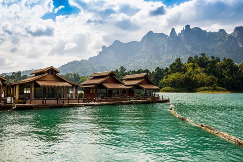 Floating houses on lake with jungle and rainforest and steep mountains, Cheow Lan Lake, Khao Sok