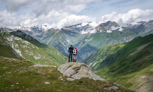 Two friends, mountaineers on a rock at the Mittagskögele, view of mountain peaks of the Venediger