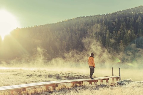 Young woman at Lake Staz near Sankt Moritz in the Engadine in Switzerland. Morning atmosphere with