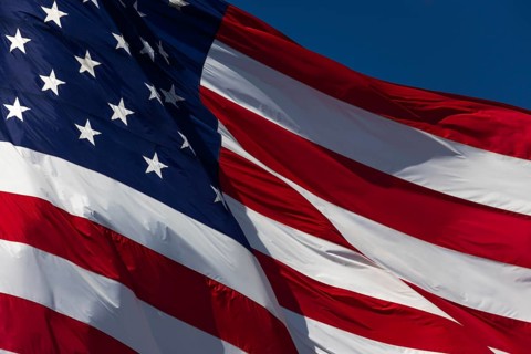 American flag waving in the wind against deep blue sky