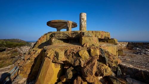 Dilapidated concrete structure on rocky ground with unobstructed view under a blue sky, Lost Place,
