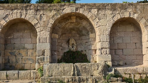 Three vaulted niches in an old stone wall in a historical site, retaining wall with niche, relief