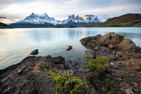 Cuernos del Paine mountain range at sunset, shore of the blue lake Lago Pehoe, Torres del Paine