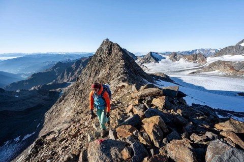 Mountaineer on a rocky ridge, ascent to the Wilder Freiger, summit of the Becher with Becherhaus