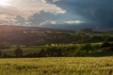 Dramatic cloudy sky with approaching storm and last rays of sunshine, Frankenhain, dark cloud wall,