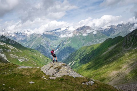Mountaineer on a rock at the Mittagskögele, view of mountain peaks of the Venediger group and the
